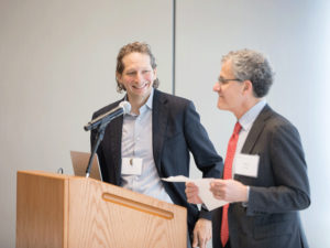 Dean Michael Sipser introduces Joshua Tenenbaum at a podium