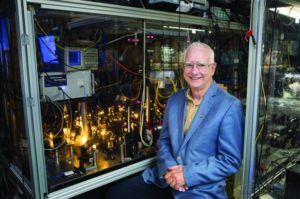 Professor David Pritcher in front of lab equipment.