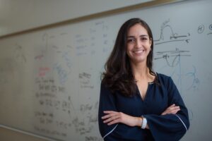 Izabella Pena stands with arms crossed in front of a whiteboard