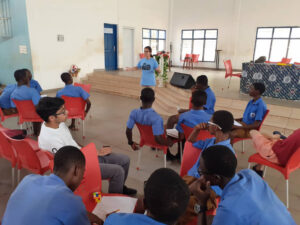 MIT student stands in front of a room of students in Africa