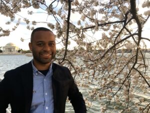 Thomas Searles in front of some cherry blossoms